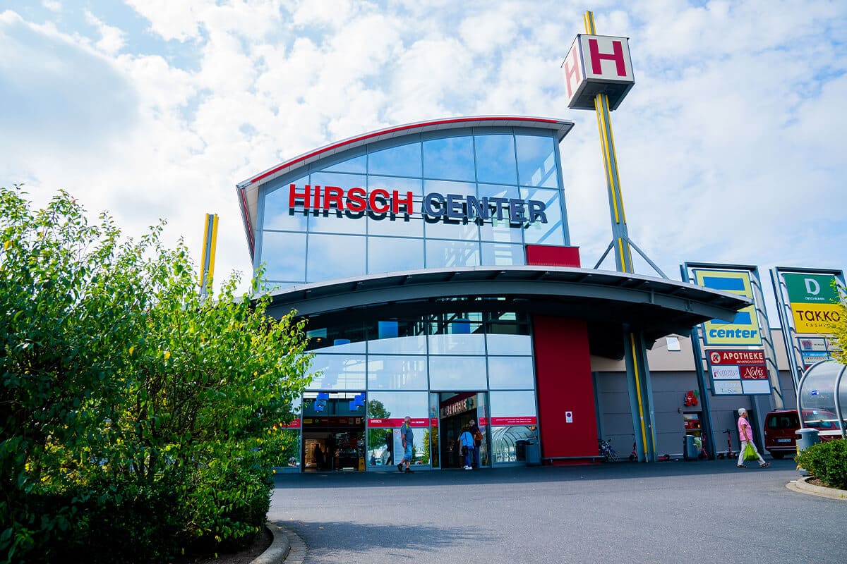 Eingang des Hirsch Centers mit großem Glasfassadenbogen