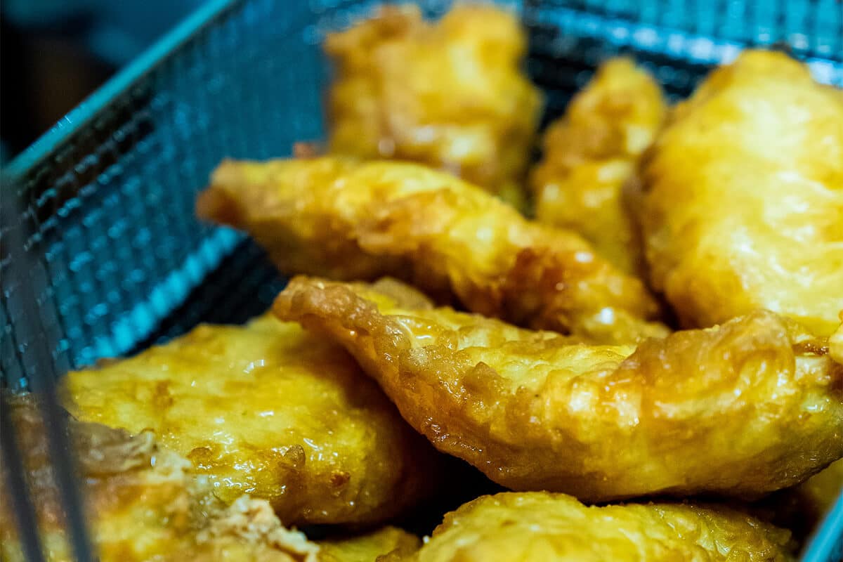 Mehrere goldbraun frittierte Fleisch in einem Metallkorb