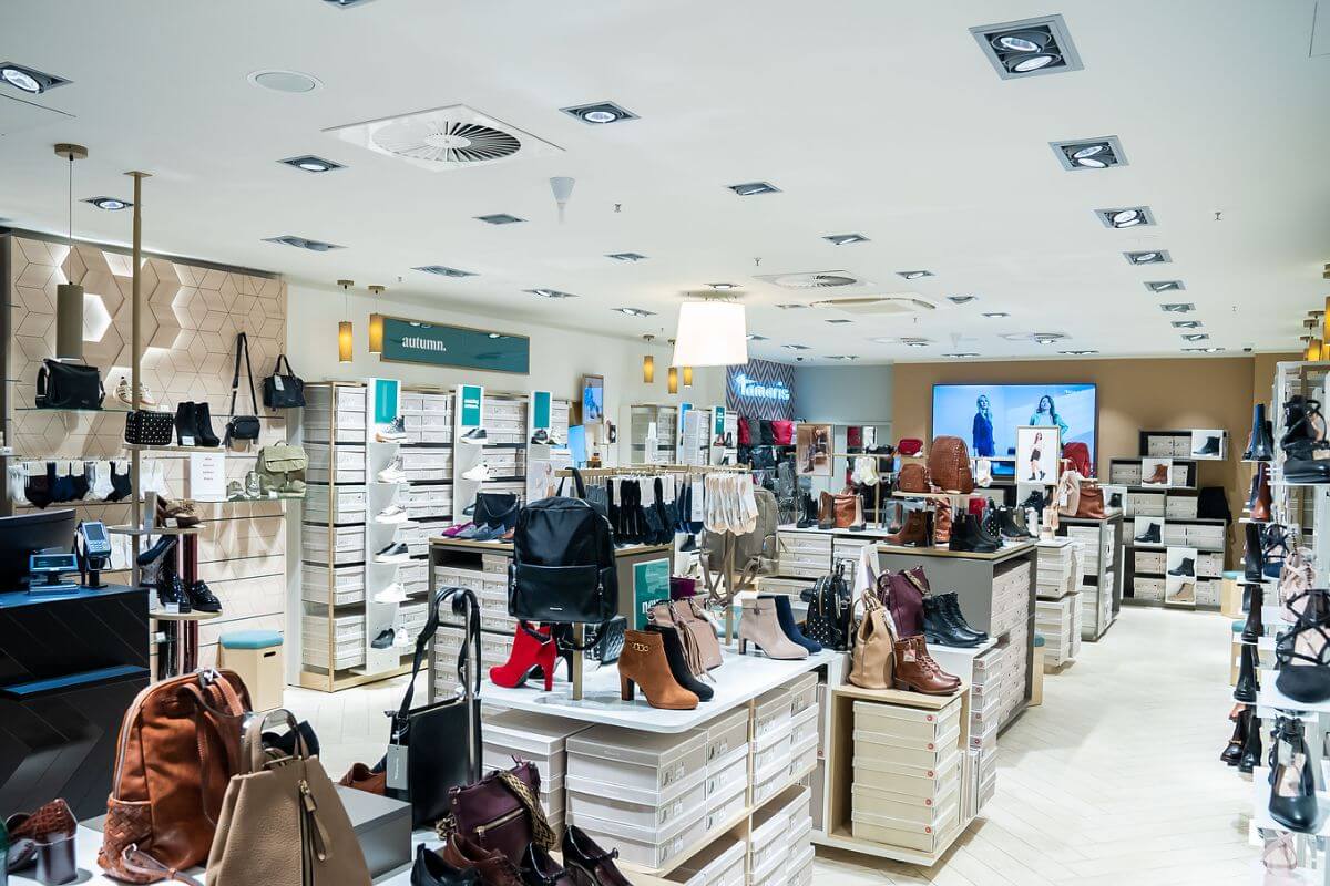 Tamaris Innenbereich mit heller Beleuchtung und geordneter Präsentation von Damenstiefeln, High Heels und Taschen