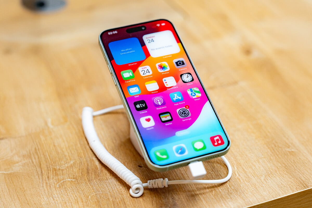 Smartphone mit buntem Startbildschirm auf einer Holzfläche