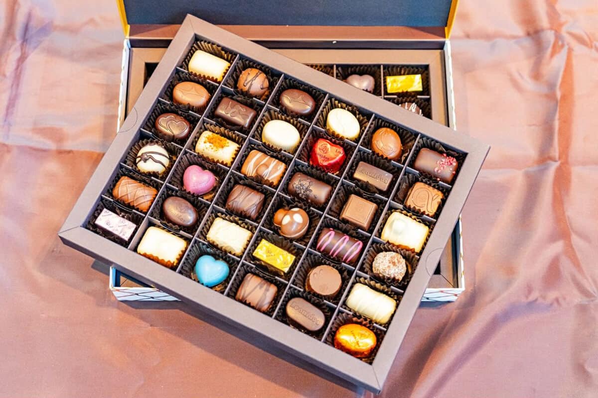 Geöffnete Pralinenschachtel mit zwei Lagen edler Leonidas-Pralinen